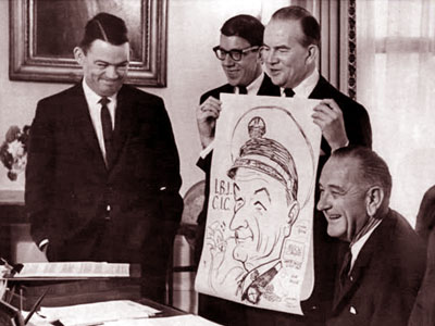 Three cartoonists visit President Johnson.  Standing, left to right: Bill Mauldin, Don Sherwood and Milton Caniff.